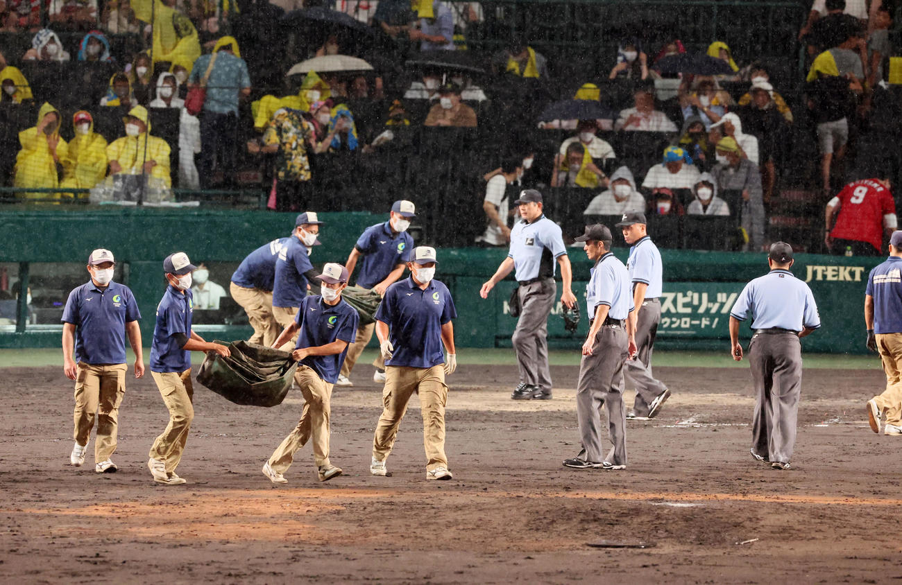 阪神対広島　7回裏、雨が強くなりグラウンドにシートをかぶせる阪神園芸の職員たち（撮影・加藤哉）