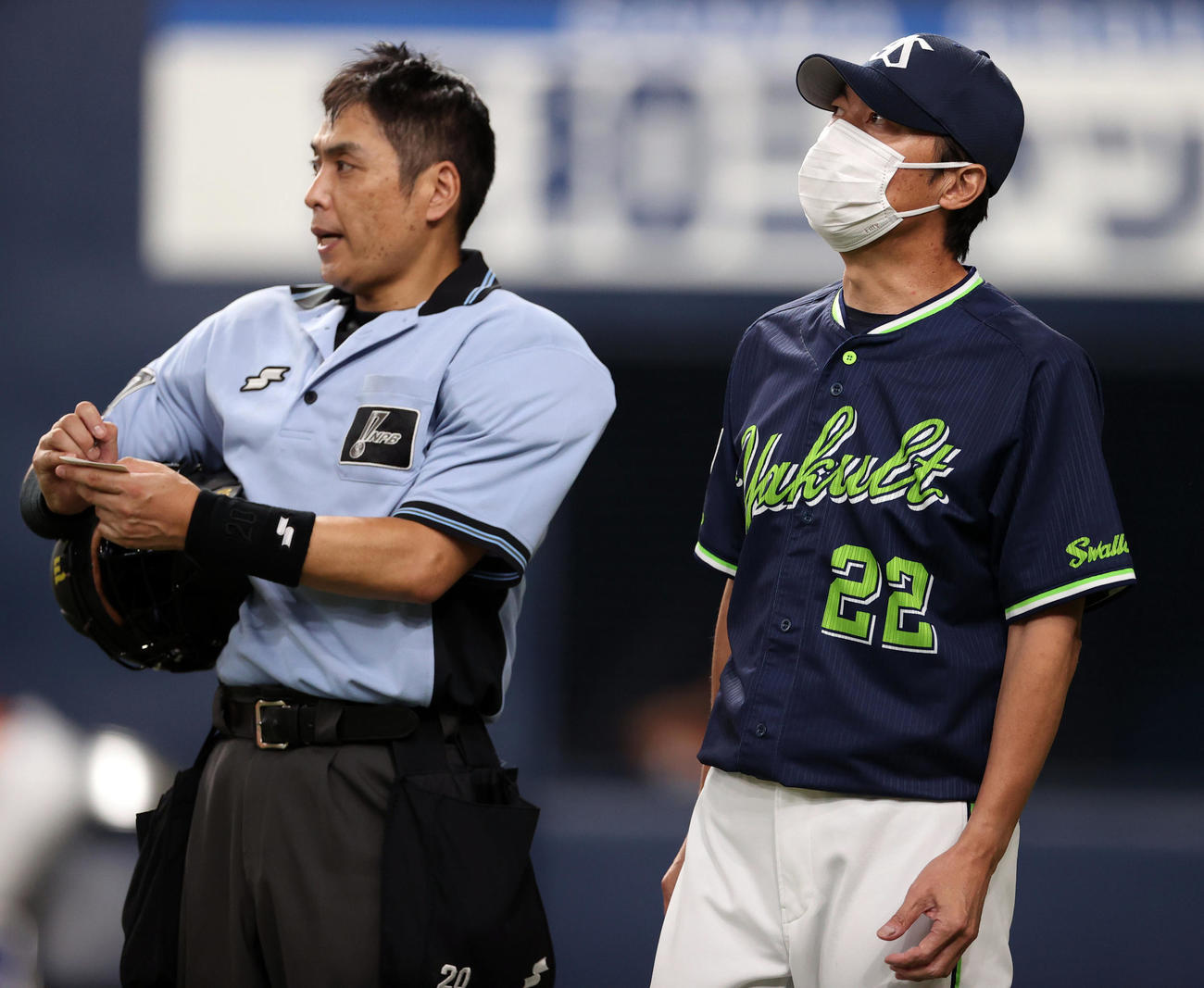 巨人対ヤクルト　7回表を終え、白井球審（左）に選手の交代を告げる高津監督（撮影・狩俣裕三）