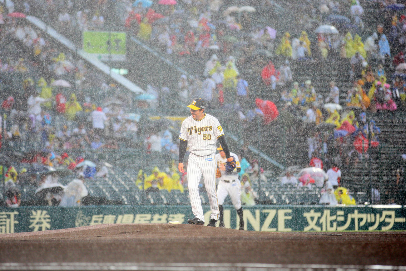 阪神対広島　阪神先発の青柳はマウンドに上がるも、雨で試合開始が見合わせとなり苦笑いする（撮影・上山淳一）