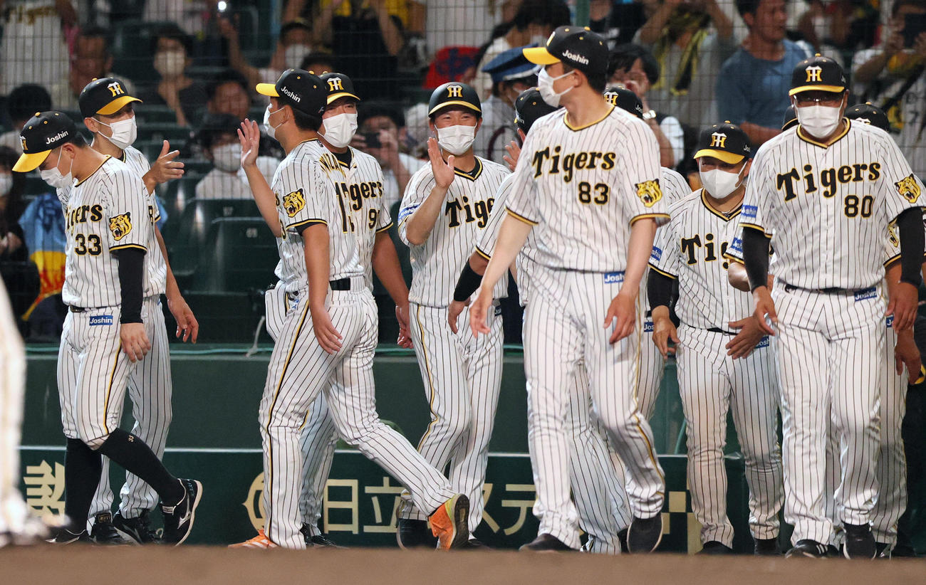 阪神対広島　広島に勝利し、阪神矢野監督（左から2人目）はベンチ前でナインとタッチを交わす（撮影・上山淳一）