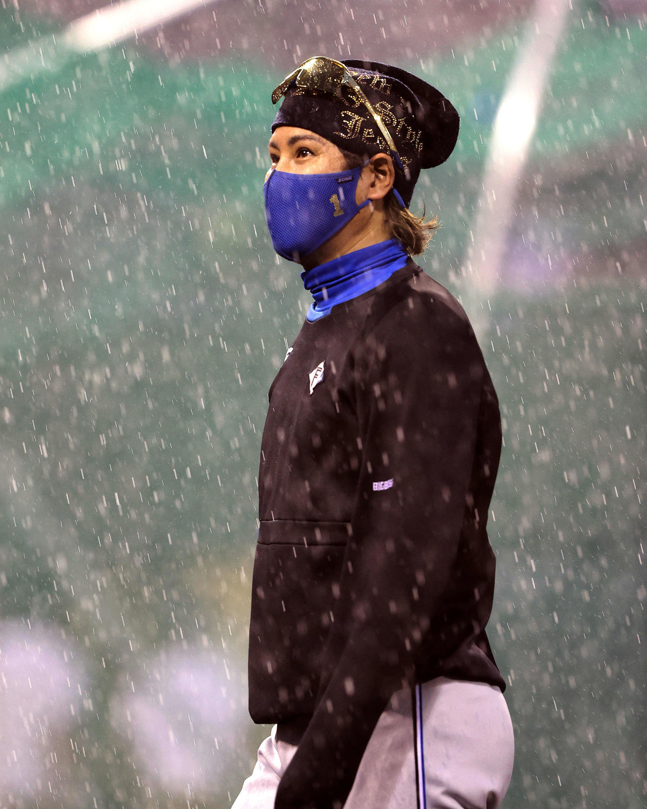 試合前練習中、土砂降りの雨の中をベンチに引き揚げる日本ハム新庄監督（撮影・鈴木正人）