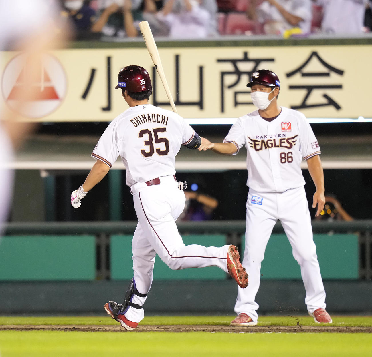 楽天対オリックス　4回裏楽天無死満塁、右越え満塁本塁打を放った島内（左）はバットを持ったまま塩川コーチとタッチを交わす（撮影・鈴木みどり）