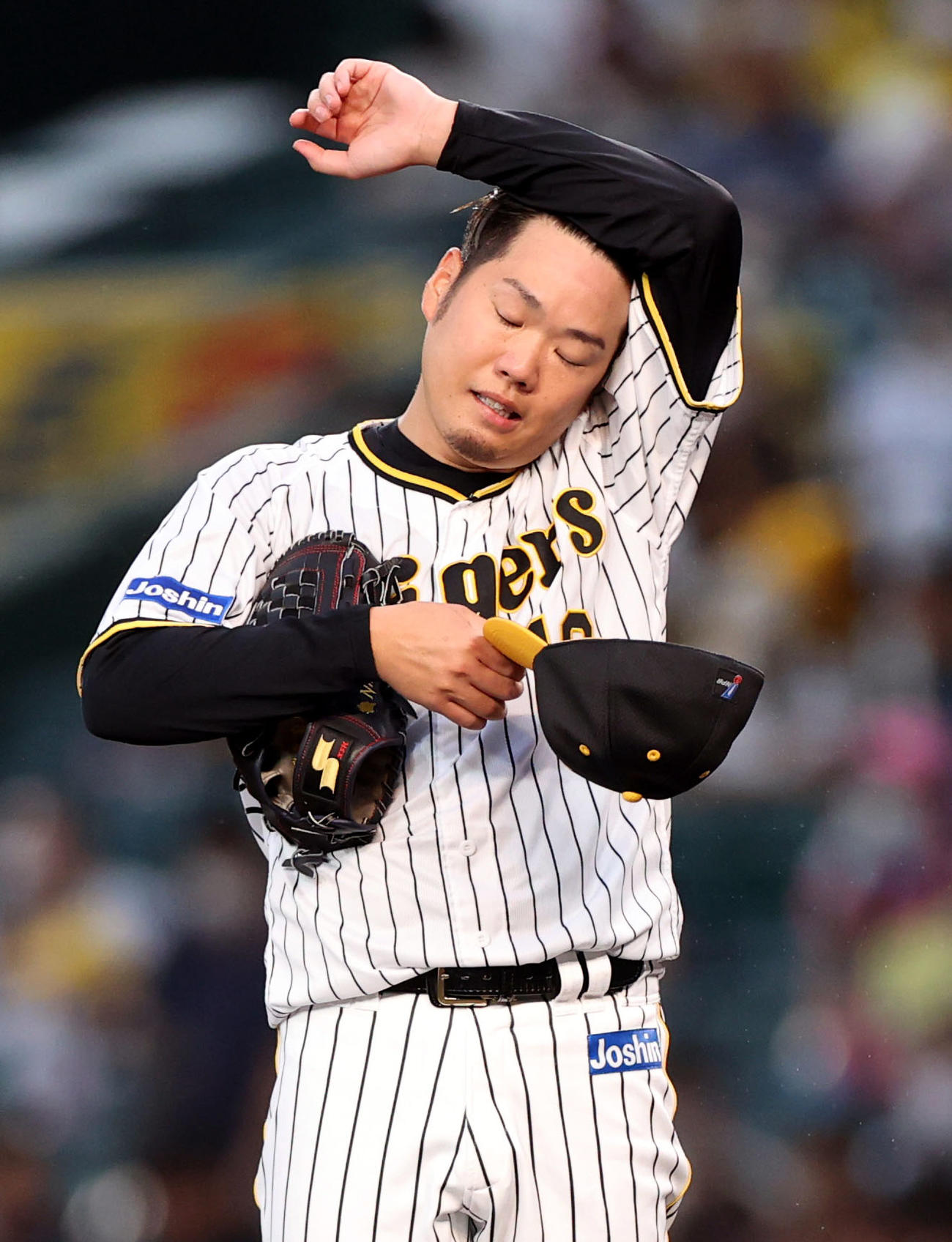 阪神対巨人　1回表巨人2死二塁、中田に四球を与え、汗をぬぐう阪神先発の西勇（撮影・狩俣裕三）