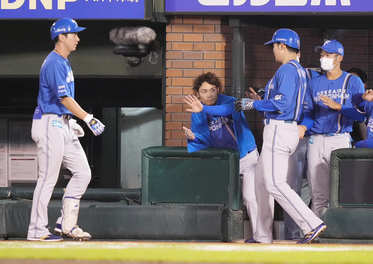 楽天対日本ハム　4回表日本ハム1死二、三塁、松本剛（左）の遊ゴロの間に生還した三塁走者清宮（右から2人目）を迎える伊藤（中央）（撮影・鈴木みどり）