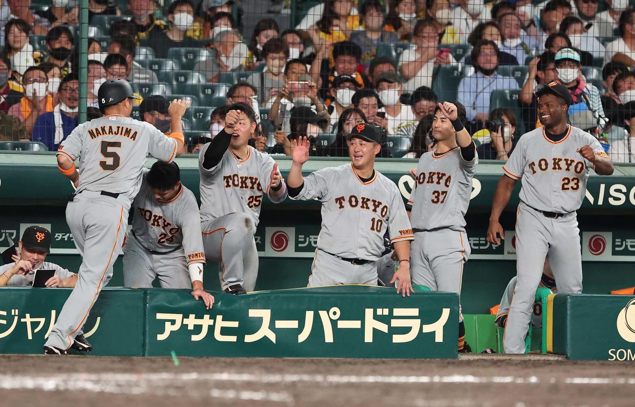9回表巨人2死一、二塁、同点適時打を放った中島（左）を笑顔で出迎える巨人ナイン（撮影・上田博志）