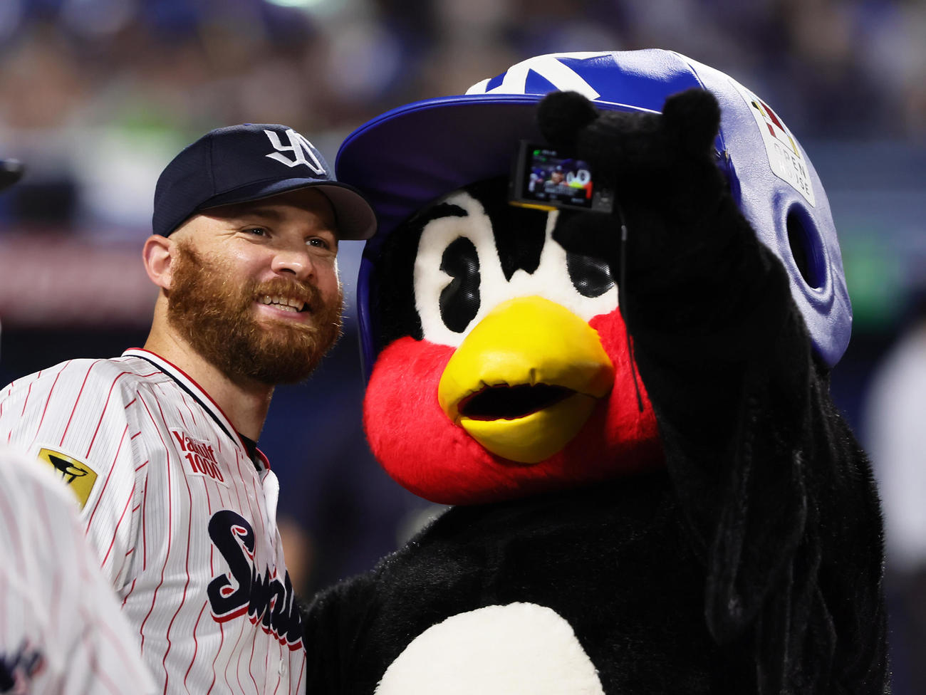 ヤクルト対中日　つば九郎との自撮りに笑顔を見せるヤクルトのサイスニード（撮影・足立雅史）