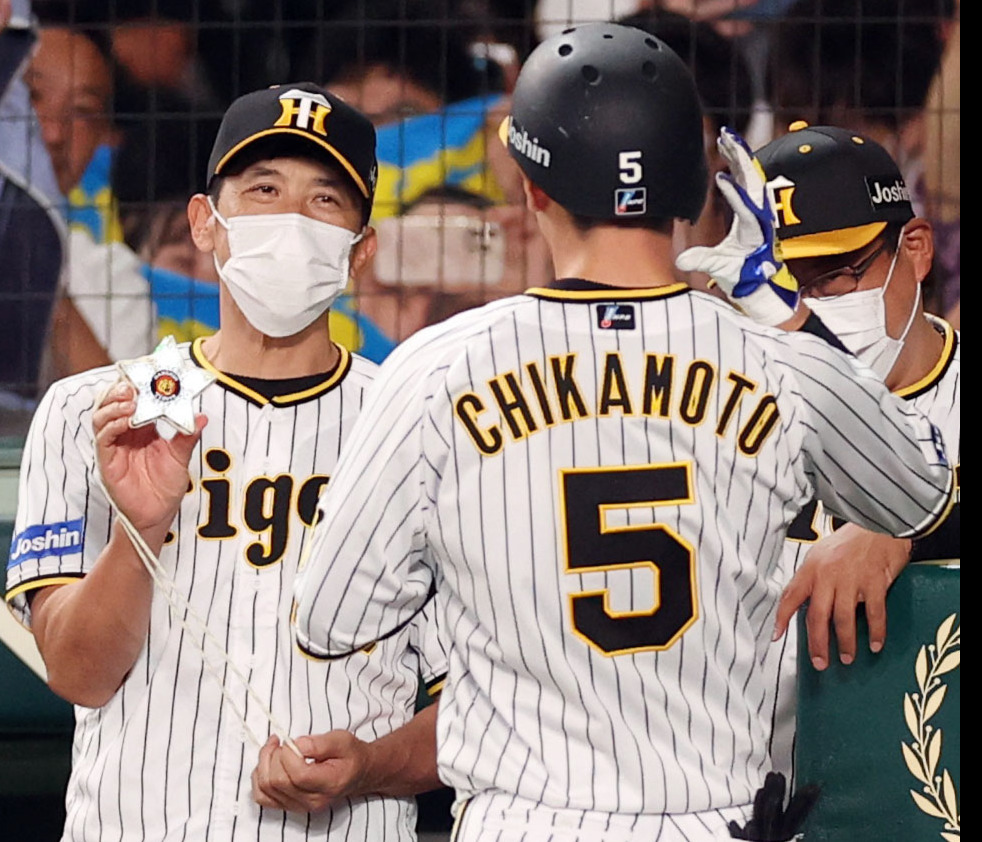 阪神対巨人　4回裏阪神1死、ソロ本塁打を放った近本（手前）にメダルをプレゼントする矢野監督（撮影・狩俣裕三）