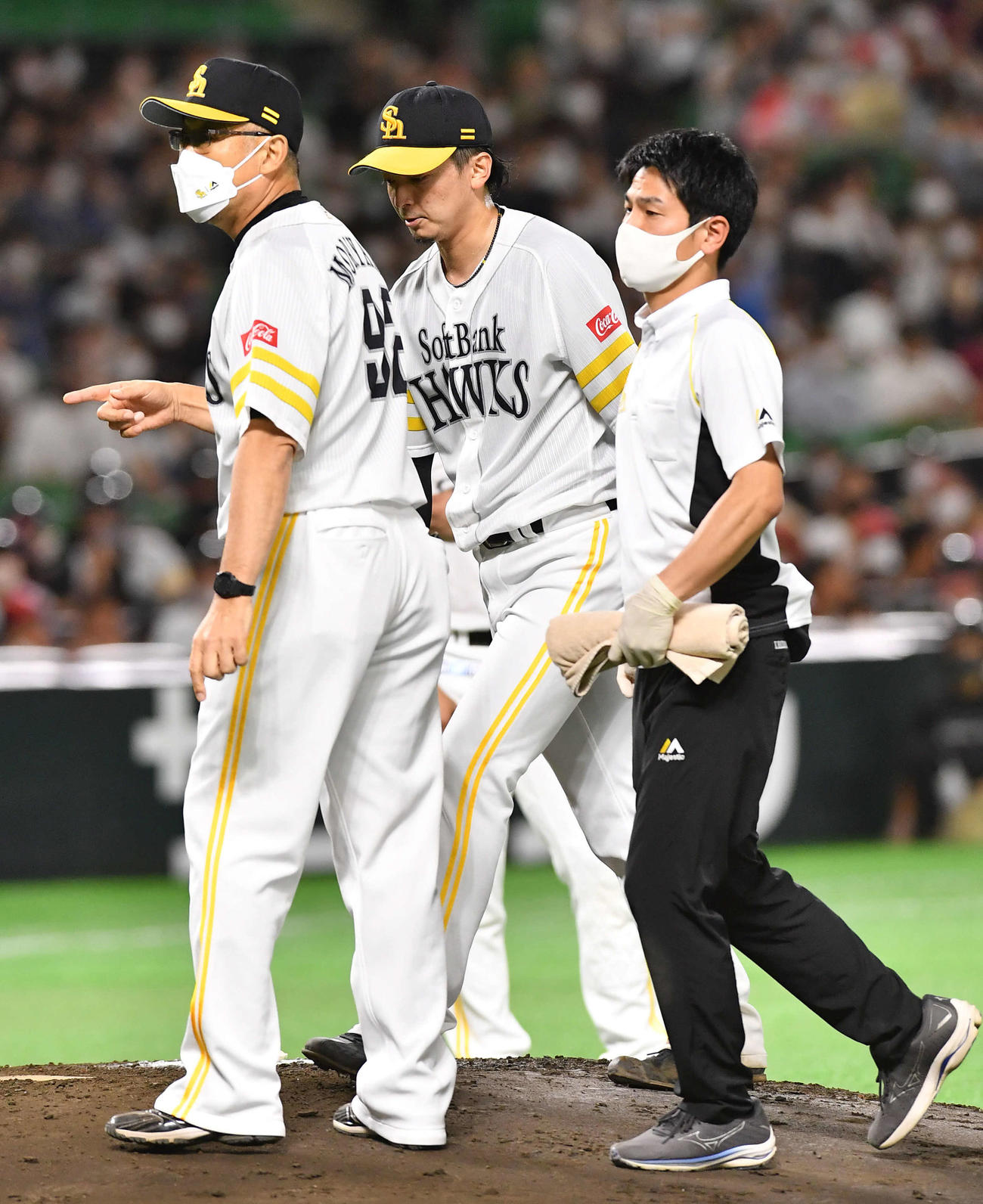 ソフトバンク対西武　6回表西武2死一、二塁、呉の打球処理で足をひねり、治療のためベンチへ戻る東浜（撮影・岩下翔太）