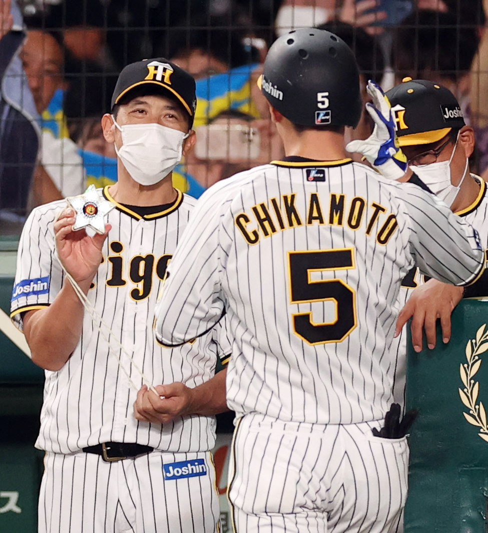 阪神対巨人　4回裏阪神1死、ソロ本塁打を放った近本（手前）にメダルをプレゼントする矢野監督（撮影・狩俣裕三）