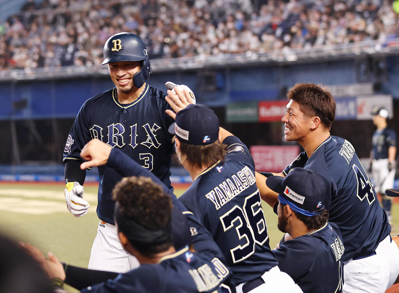 ロッテ対オリックス　6回表オリックス2死一、三塁、生還した安達（左）はナインの出迎えを受ける（撮影・垰建太）