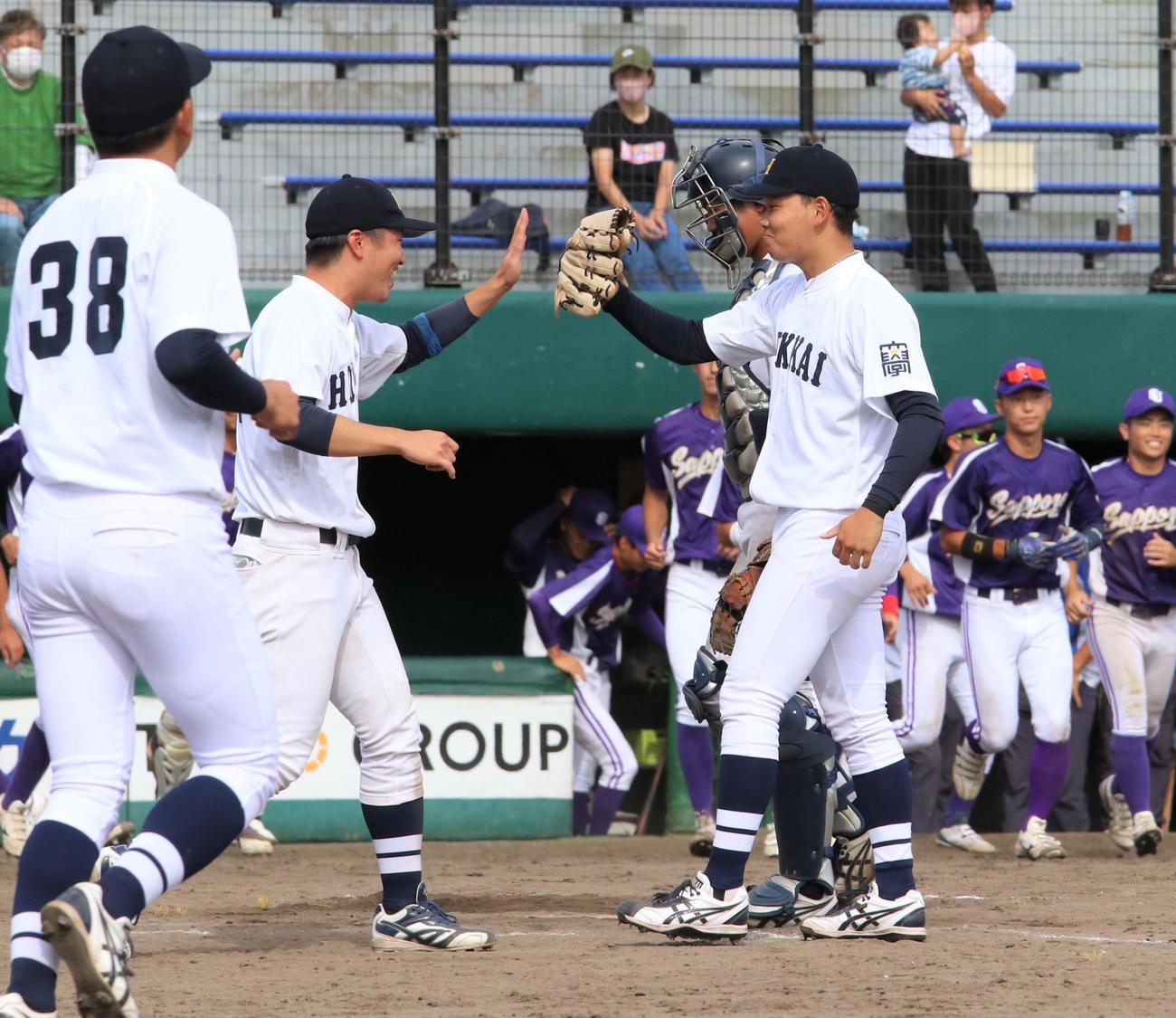 札幌大対北海学園大　勝利し試合後ナインとタッチする北海学園大の帯川瑠（右）（撮影・石井翔太）