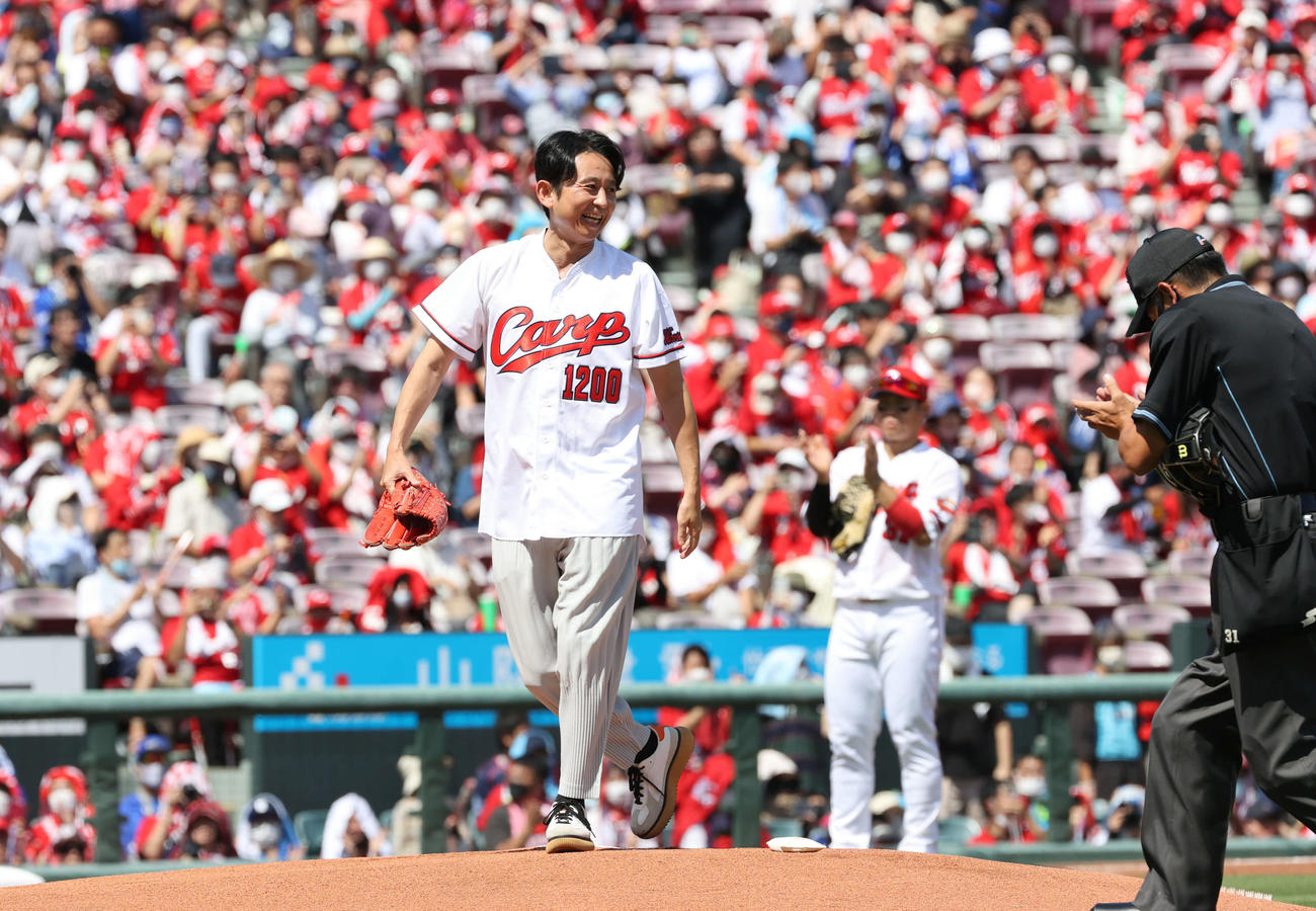 広島対DeNA　始球式で投球し、笑顔をみせる有吉弘行。右から2人目は坂倉（撮影・加藤孝規）