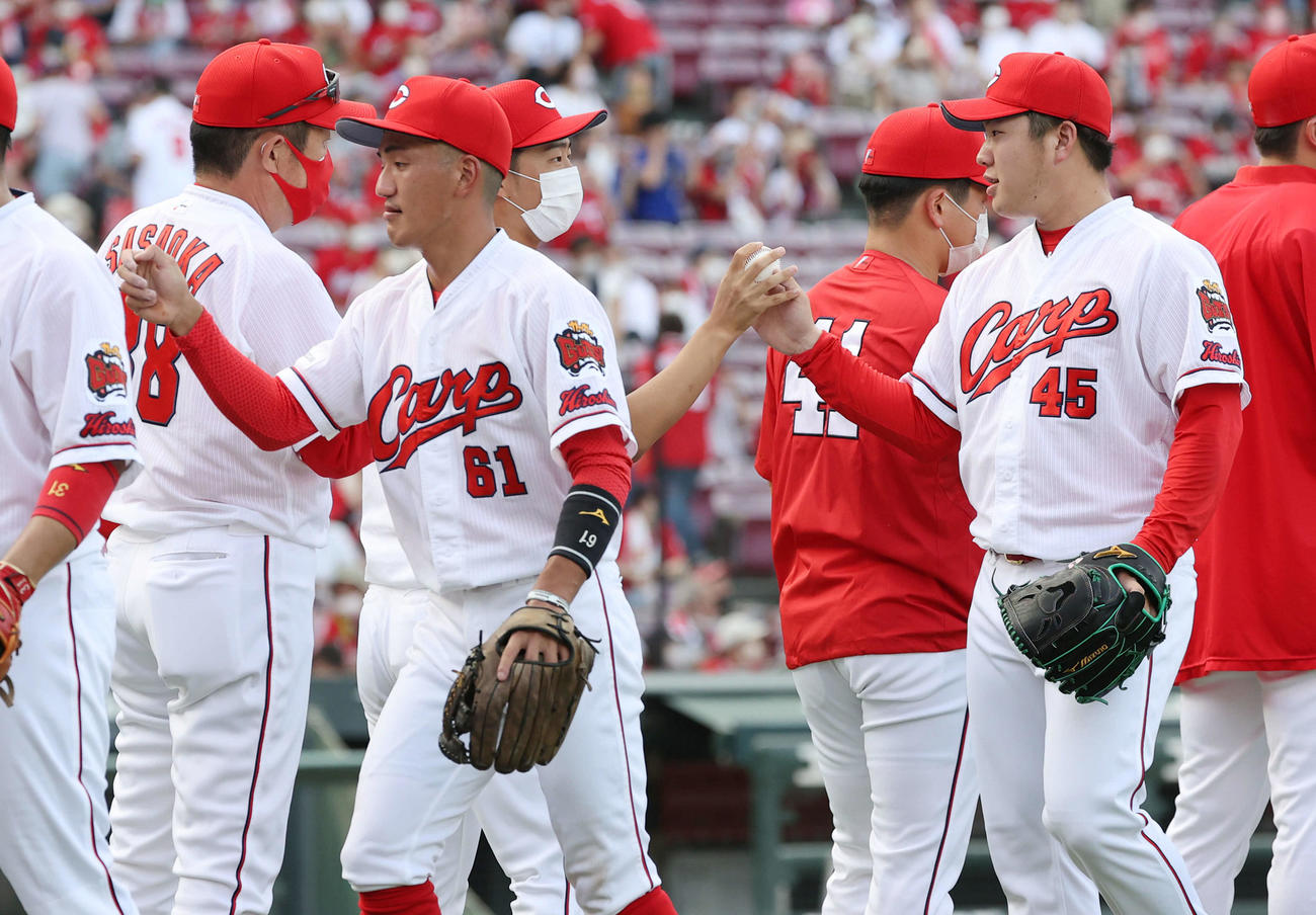 広島対DeNA　最後を締めた松本（右）からウイニングボールを受け取る玉村（中央）。左は佐々岡監督（撮影・加藤孝規）
