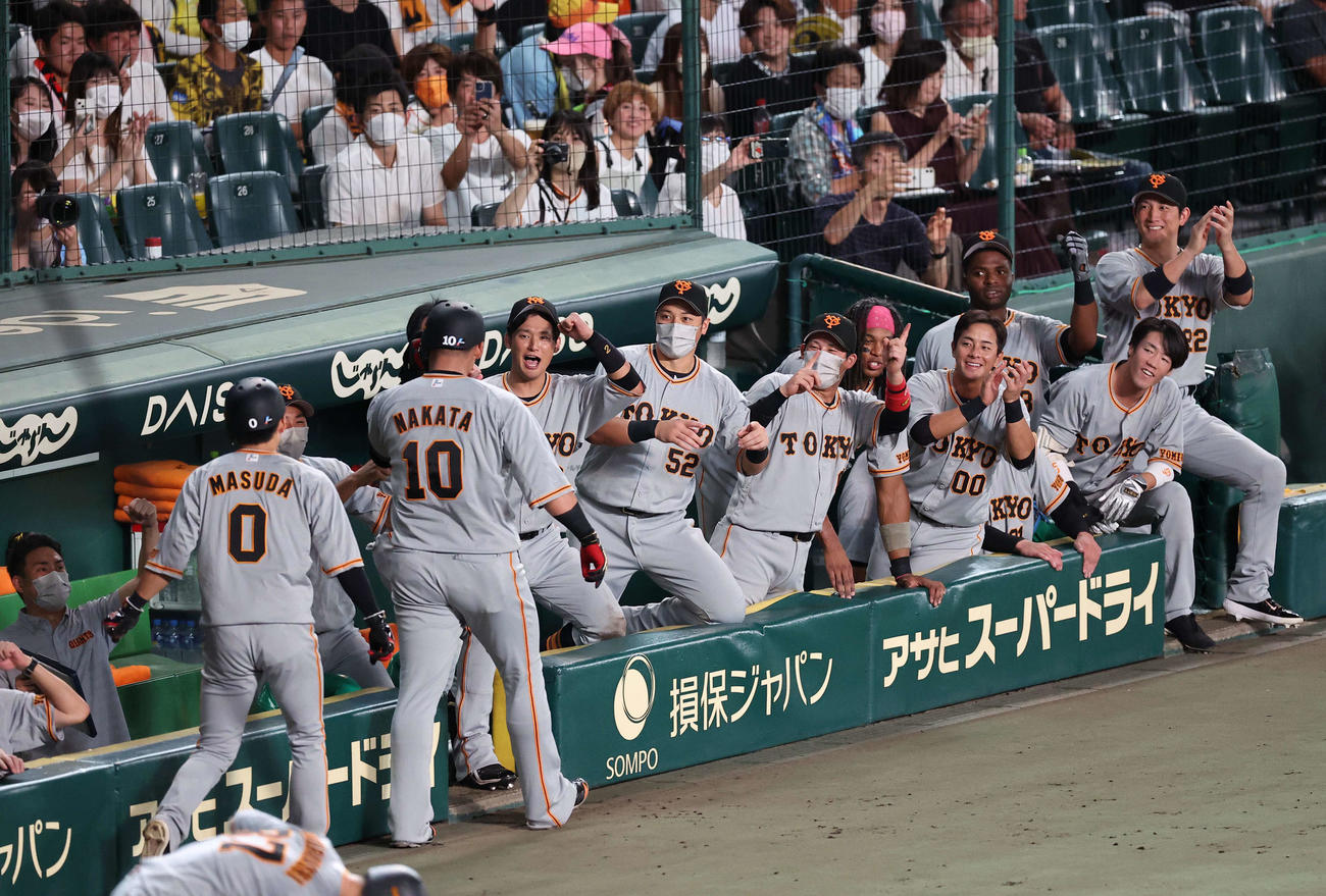 阪神対巨人　7回表巨人無死一塁、左越え本塁打を放った中田（左から3人目）を笑顔で出迎える巨人ナイン（撮影・上田博志）