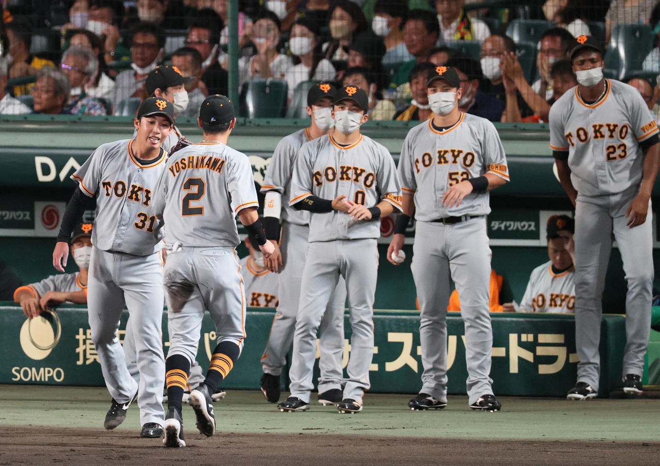 阪神対巨人　3回裏阪神2死一、三塁、赤星（左から2人目）は近本を二ゴロに仕留め二塁手吉川（手前）をベンチ前で出迎える（撮影・上山淳一）