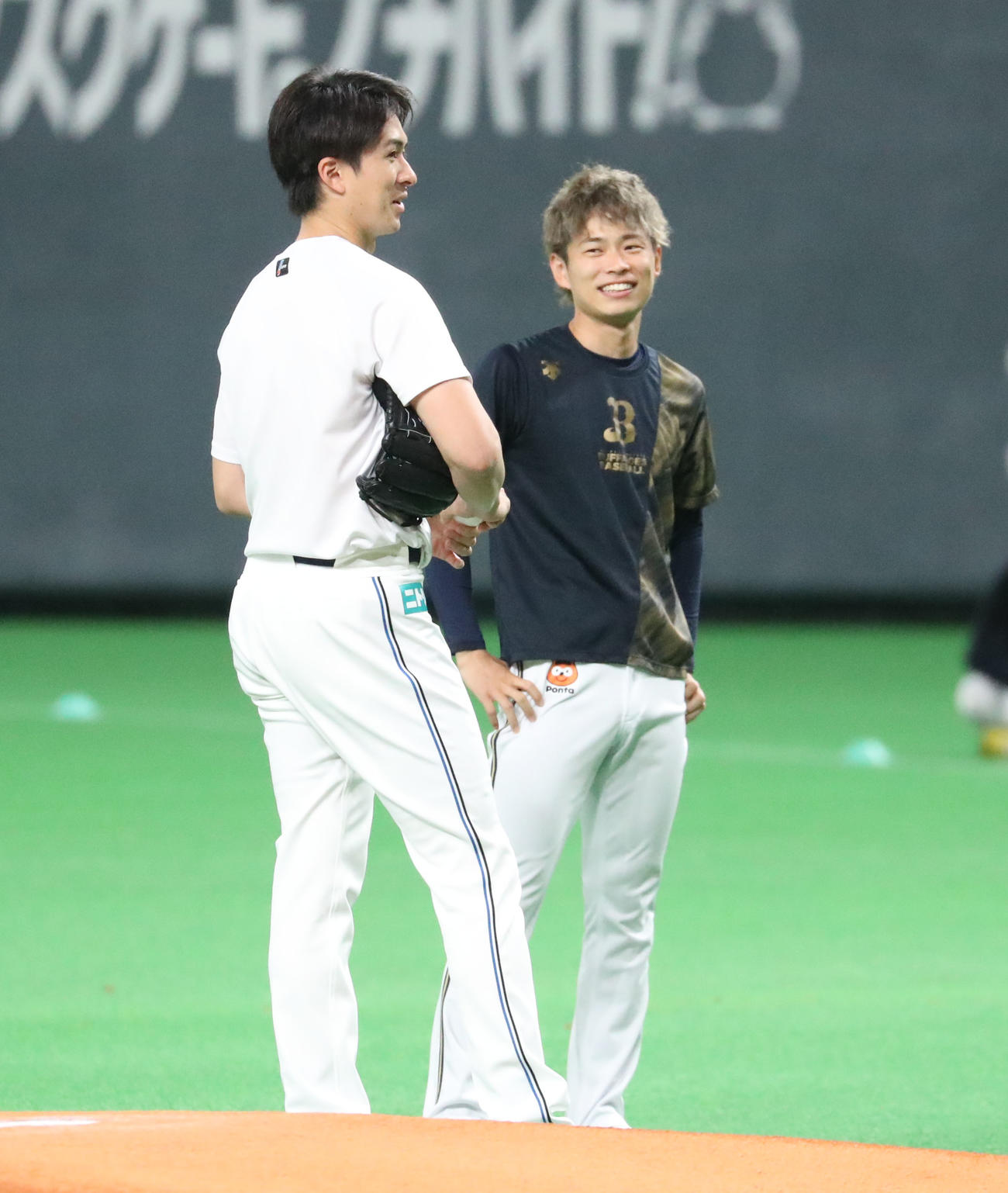 試合前に談笑する日本ハム上沢（左）とオリックス山岡（2022年7月2日撮影）