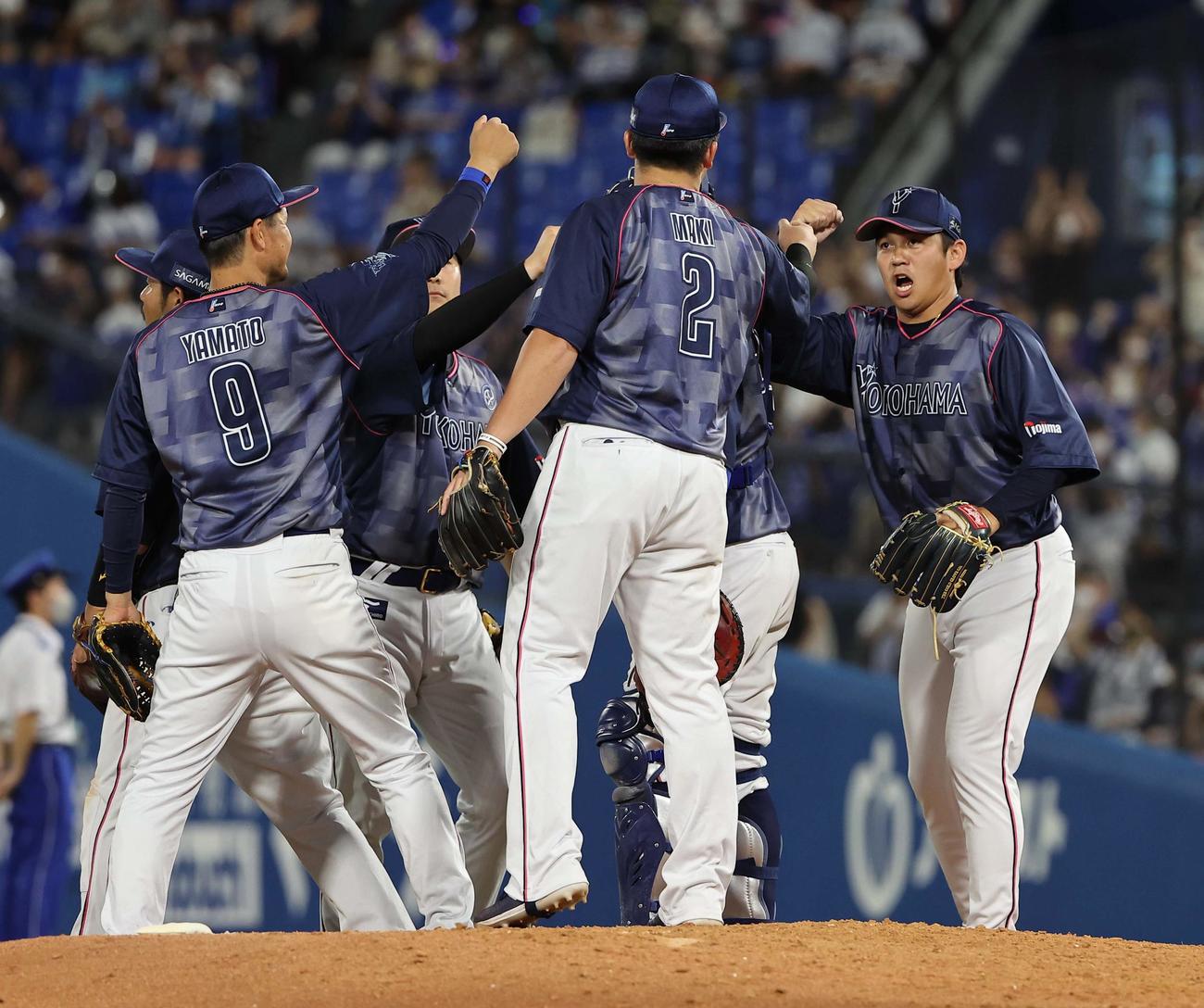 6月29日、阪神に勝利しマウンドでハイタッチする山崎（右）らDeNAナイン