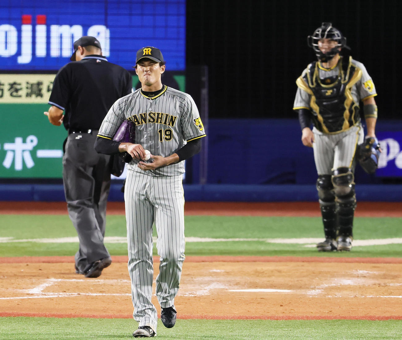 DeNA対阪神　5回裏DeNA1死三塁、代打オースティンに対し2球続けての暴投で2点を失い渋い顔を見せる藤浪（左）。捕手梅野（撮影・足立雅史）