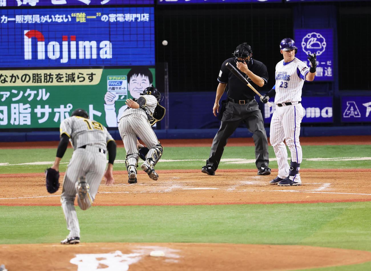 DeNA対阪神　5回裏DeNA1死二、三塁、代打オースティン（右）に対し暴投で失点する藤浪（左）。捕手梅野（撮影・足立雅史）