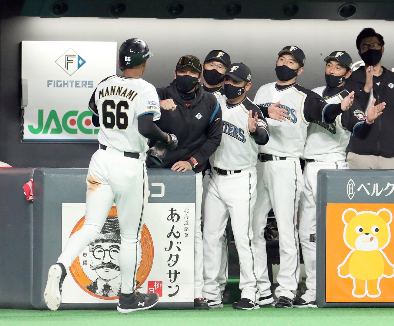 日本ハム対オリックス　2回裏日本ハム2死一、三塁、谷内の右前適時打で生還した万波（左手前）を出迎える新庄監督（撮影・佐藤翔太）