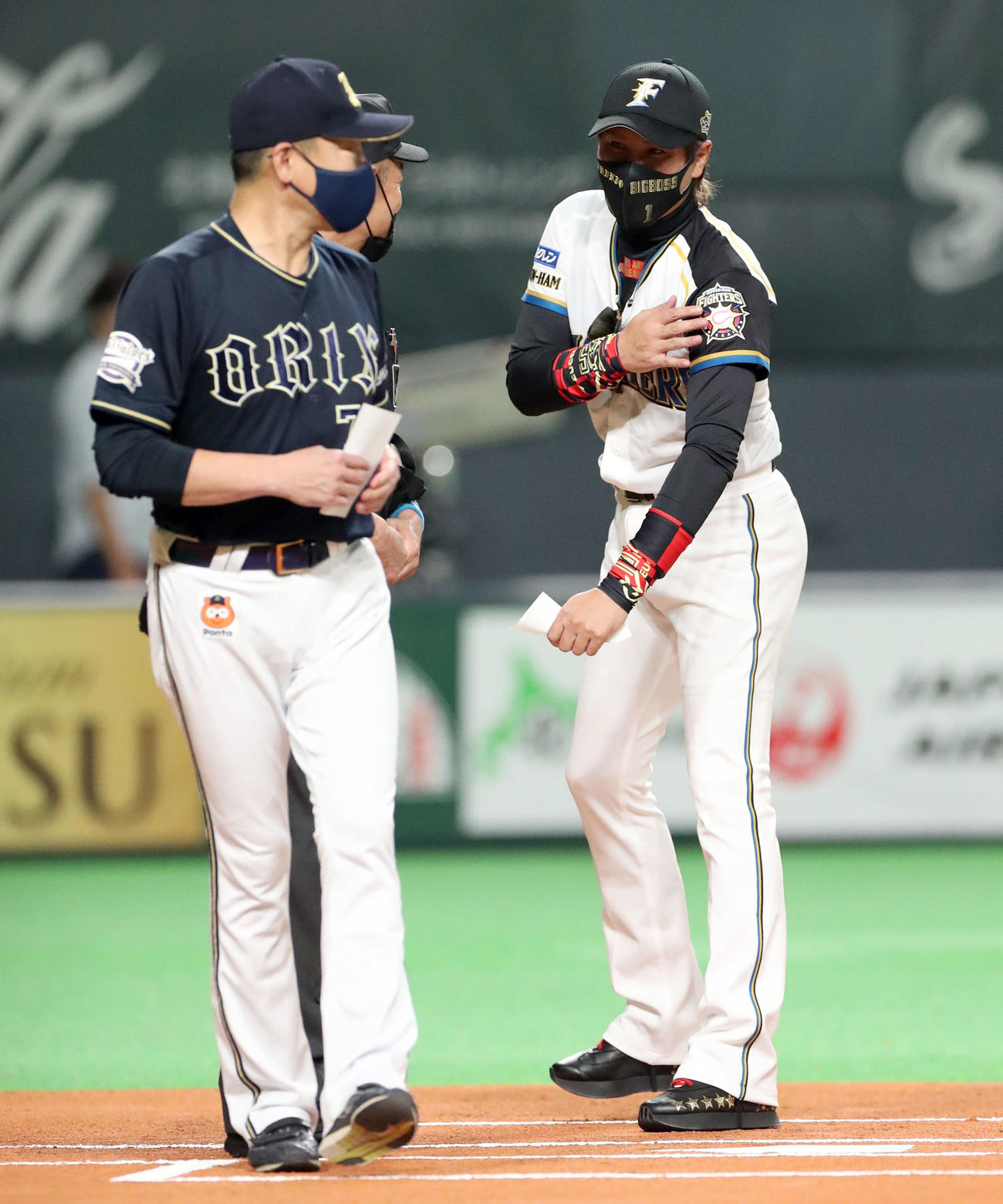 日本ハム対オリックス　北海道移転後初代のユニホームでメンバー表を交換し左腕のエンブレムを見せる新庄監督（撮影・佐藤翔太）