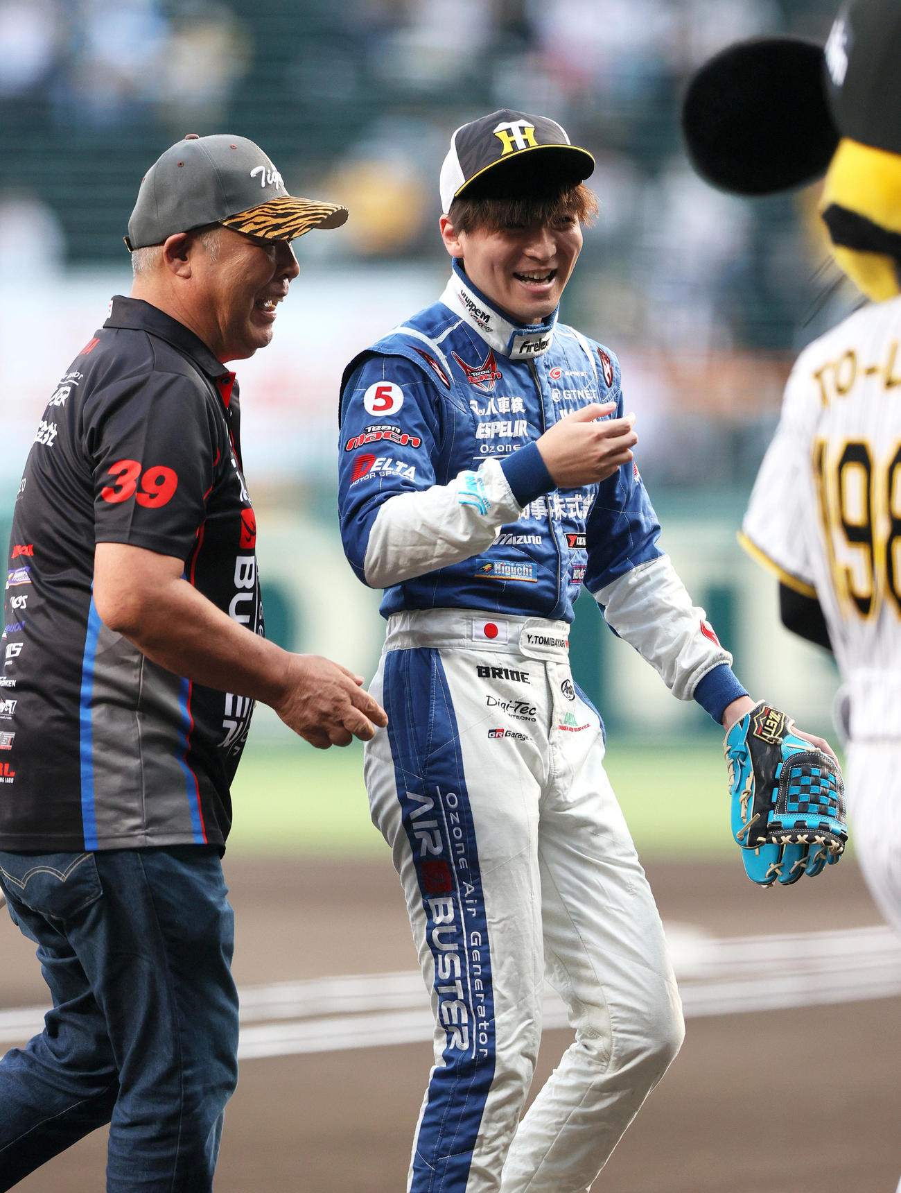 阪神対ヤクルト　ファーストピッチを終え笑顔を見せる三友商事・GTレーサーの冨林勇佑（右）（撮影・上山淳一）