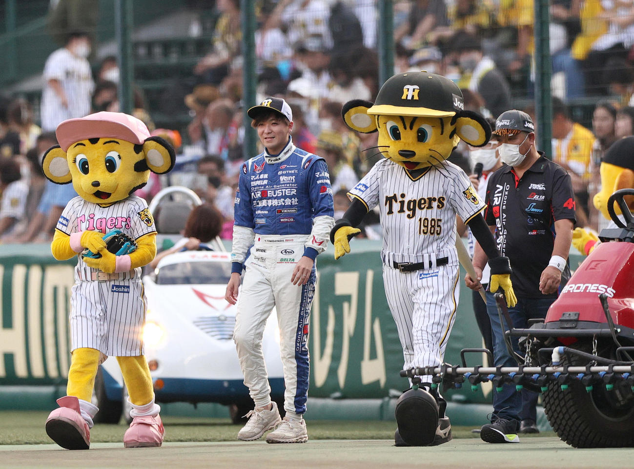 阪神対ヤクルト　ファーストピッチでマウンドに向かう三友商事・GTレーサーの冨林勇佑（左）（撮影・上山淳一）