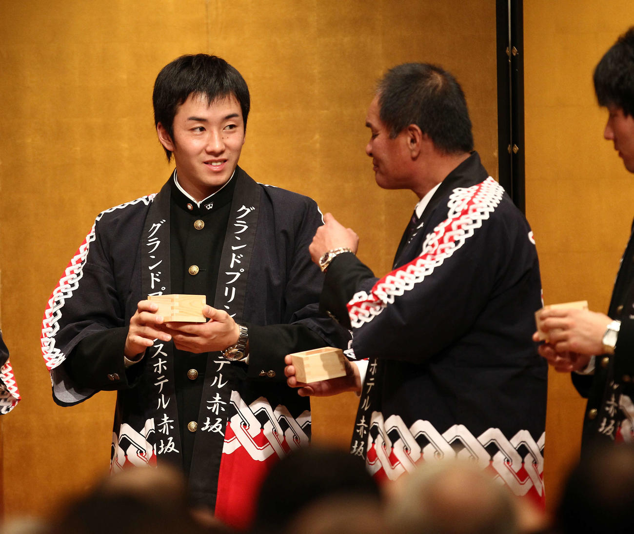 10年12月、鏡開きの後、升酒を応武監督（右）に勧められる早大・斎藤