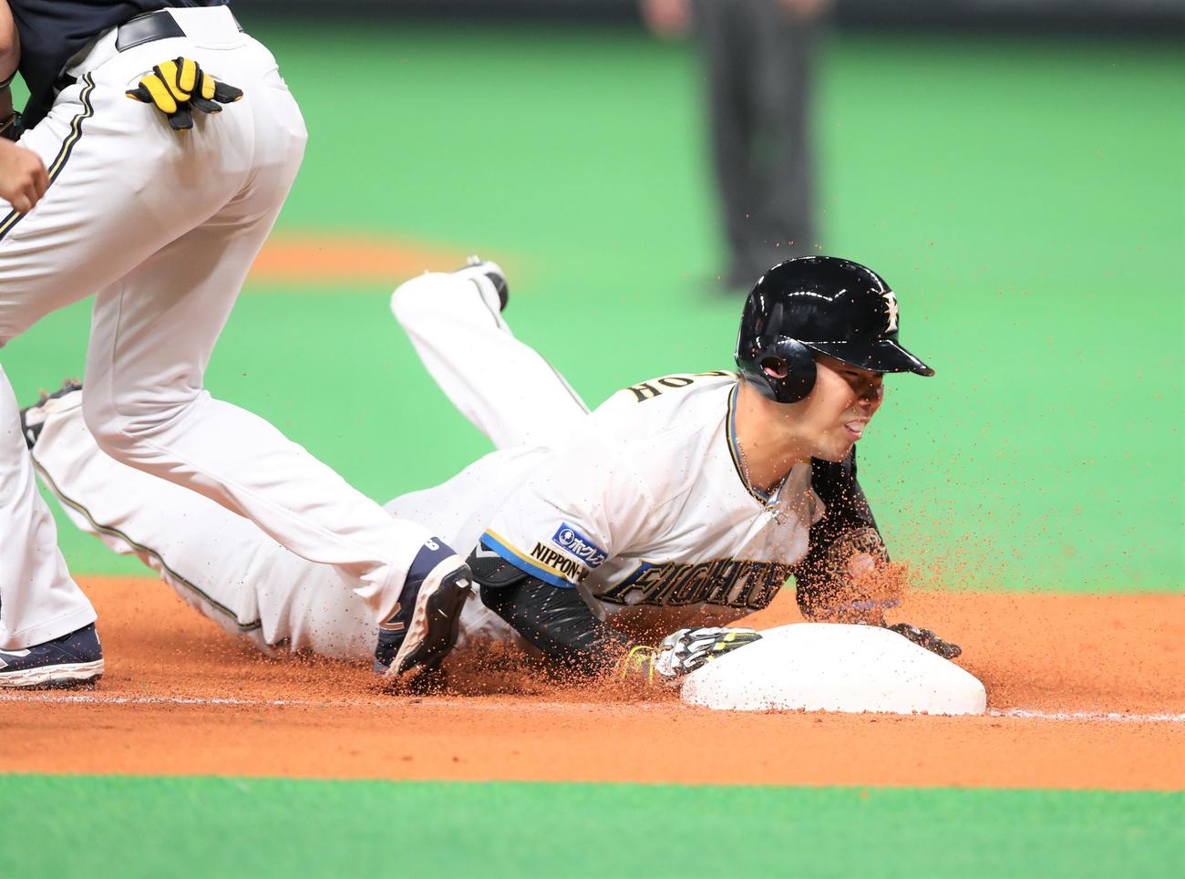 日本ハム対オリックス　7回裏日本ハム1死二塁、右越え適時二塁打を放った近藤は守備が乱れる間に三塁にヘッドスライディングする（撮影・黒川智章）