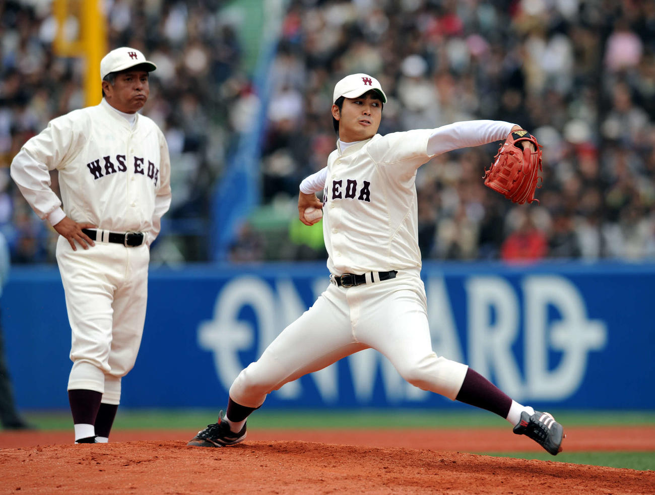 10年10月、慶大戦で投球練習する早大・大石（右）と応武監督