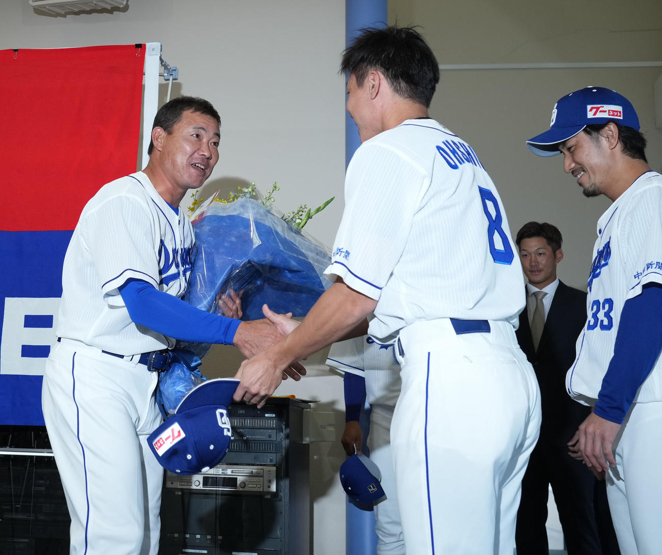 福留孝介引退会見　大島ら後輩から花束を贈られ一人一人と握手を交わす福留（左）（撮影・森本幸一）