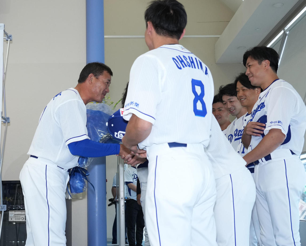 福留孝介引退会見　大島ら後輩から花束を贈られ一人一人と握手を交わす福留（左）（撮影・森本幸一）