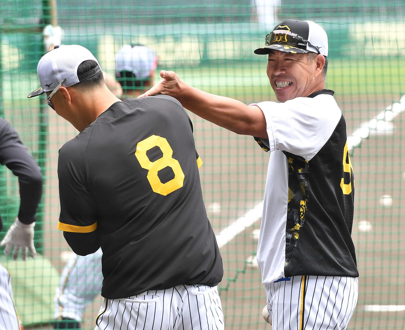 佐藤輝明（左）と談笑する井上一樹ヘッドコーチ（2022年5月26日撮影）