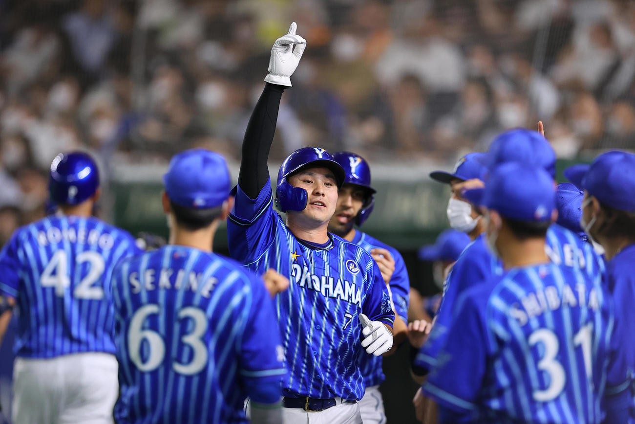 4回表DeNA2死満塁、伊藤光の適時二塁打で生還しナインの出迎えを受ける佐野（中央）（撮影・垰建太）