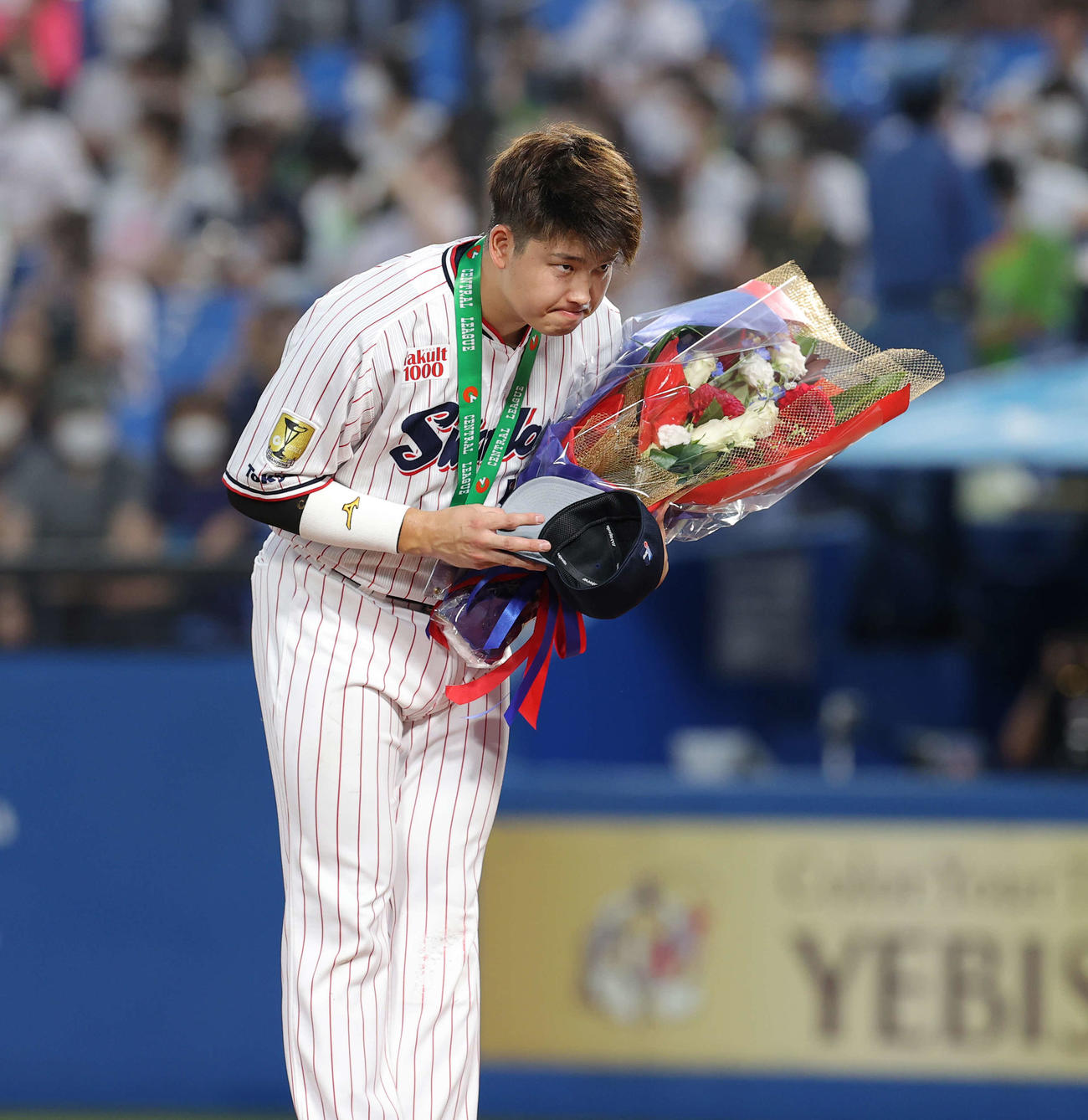 史上最年少でプロ通算150号本塁打を達成した村上は花束を受け取る（撮影・井上学）