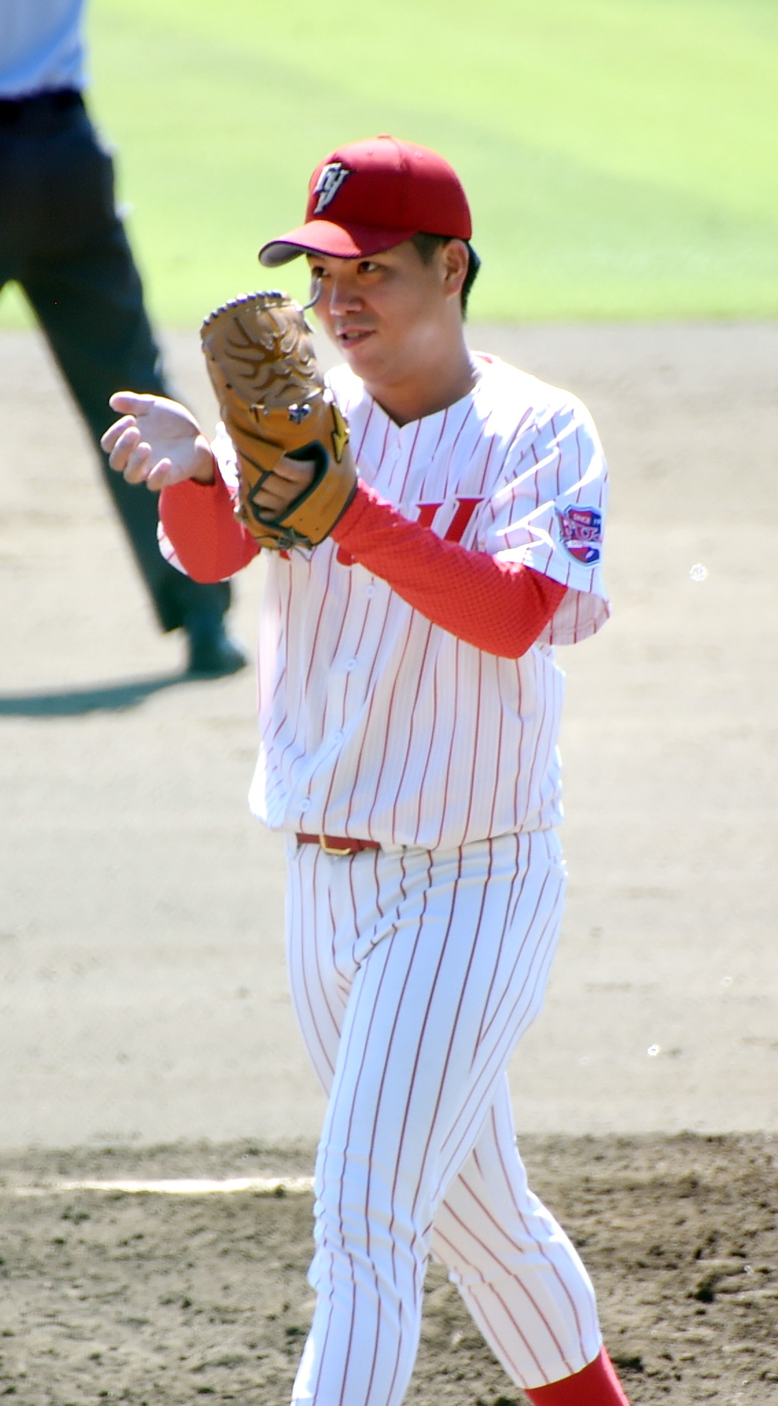 2回裏ノースアジア大2死一塁、富士大・捕手成田景が盗塁を阻止してグラブ越しに拍手する金村（撮影・山田愛斗）
