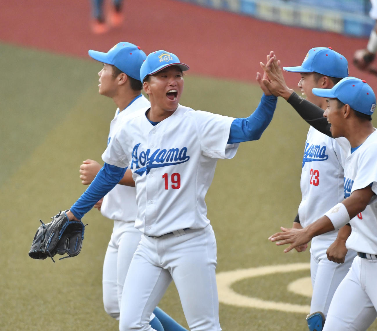亜大対青学大　2安打完封勝利を挙げた青学大・北村（左）はナインととハイタッチする（撮影・柴田隆二）