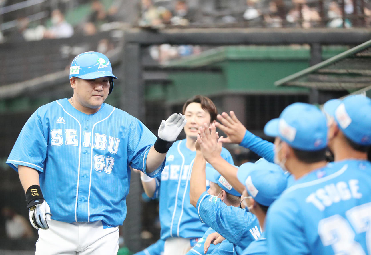 西武対日本ハム　1回裏西武無死、ソロ本塁打を放ち、源田（後方）らに迎えられる中村（撮影・狩俣裕三）