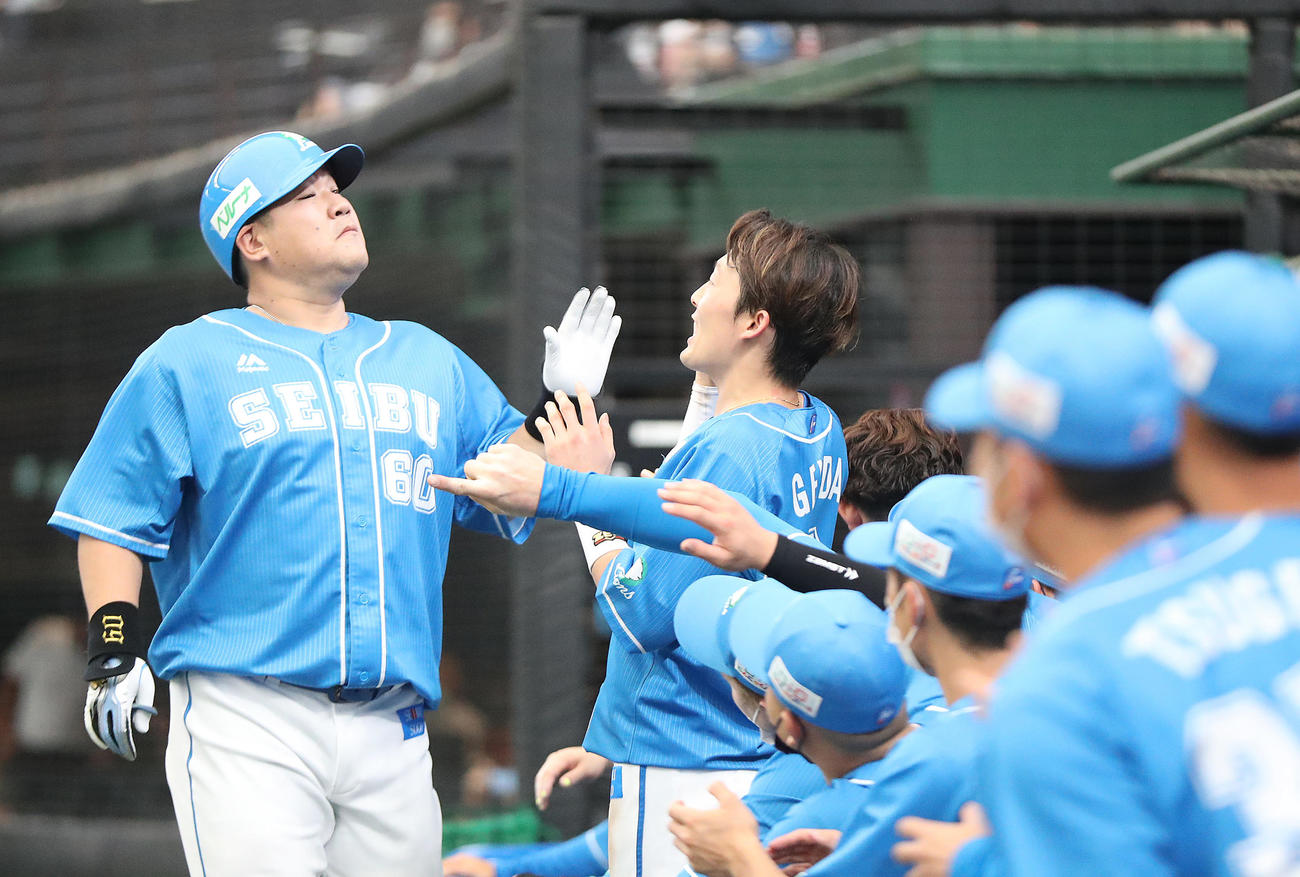 西武対日本ハム　1回裏西武無死、ソロ本塁打を放ち、源田（右）らに迎えられる中村（撮影・狩俣裕三）