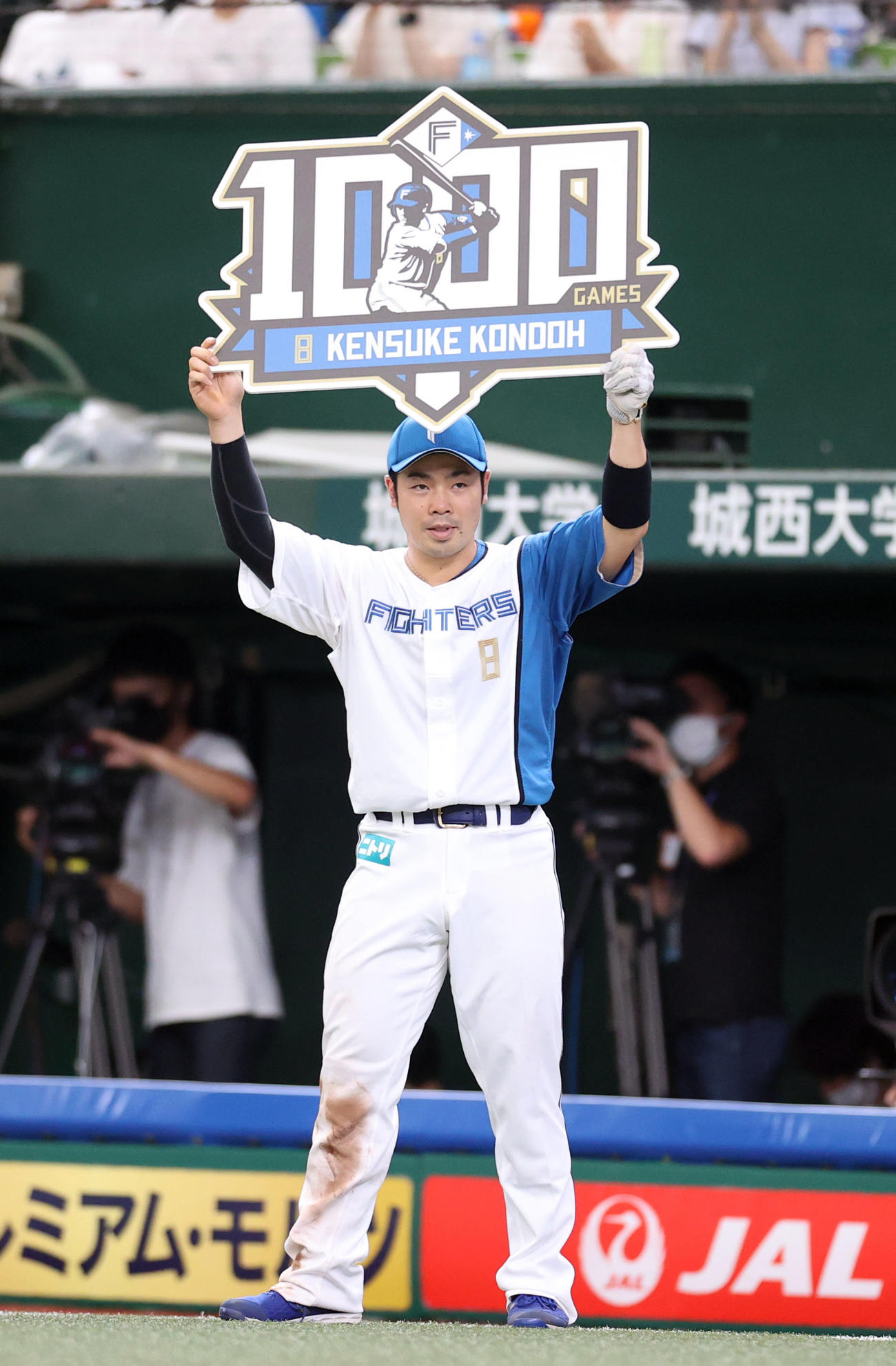 西武対日本ハム　5回裏を終え、通算1000試合出場を達成し、ボードを掲げる近藤（撮影・狩俣裕三）