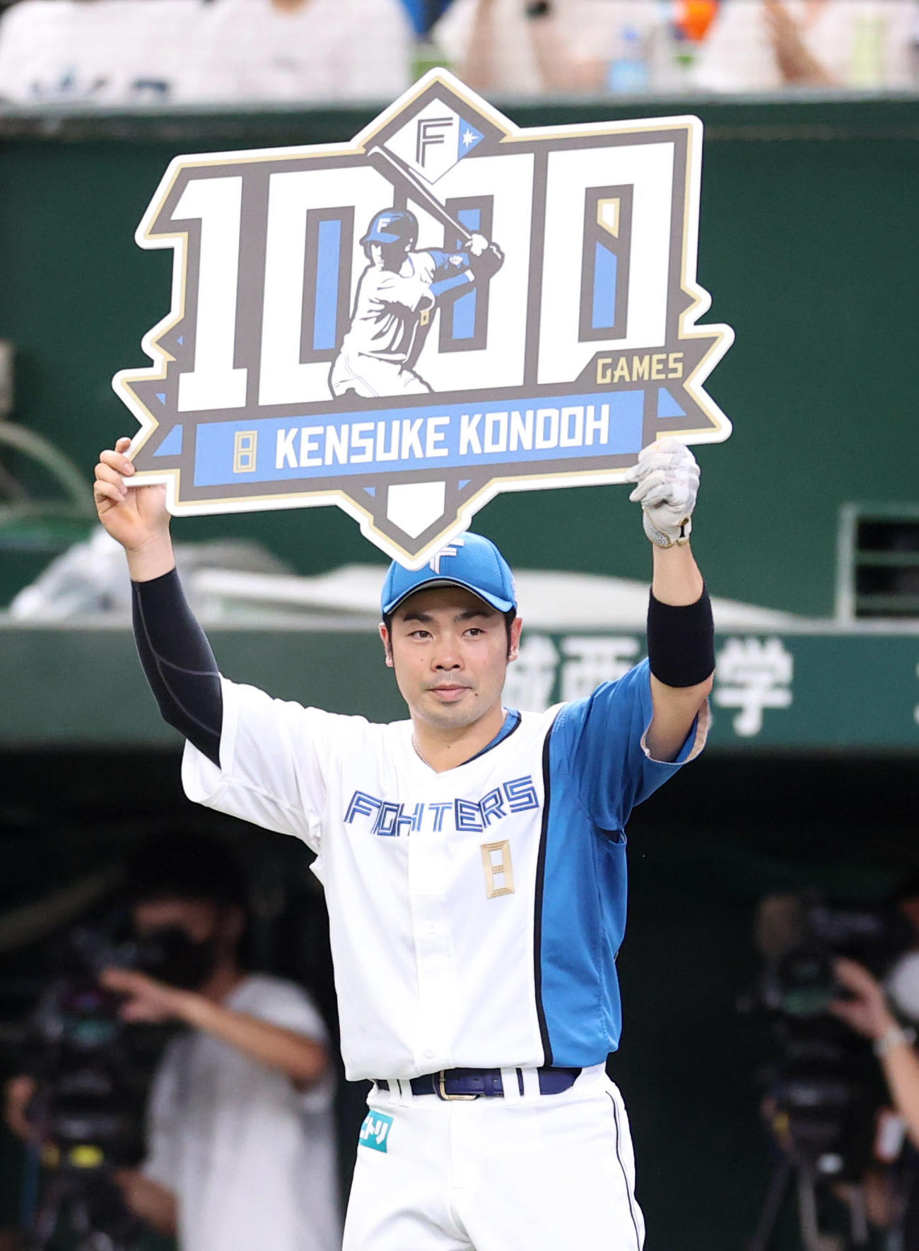 西武対日本ハム　5回裏を終え、通算1000試合出場を達成し、ボードを掲げる近藤（撮影・狩俣裕三）