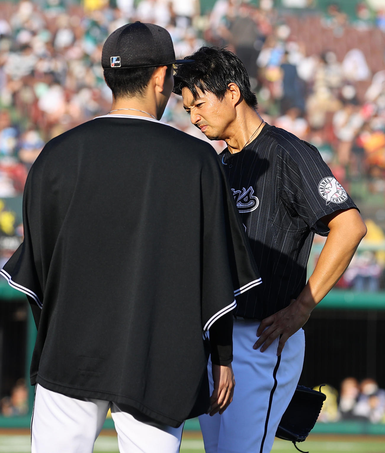 楽天対ロッテ　8回裏の登板を終え勝ち越されたロッテ唐川（右）は小島に申し訳なさそうに引き揚げる（撮影・垰建太）