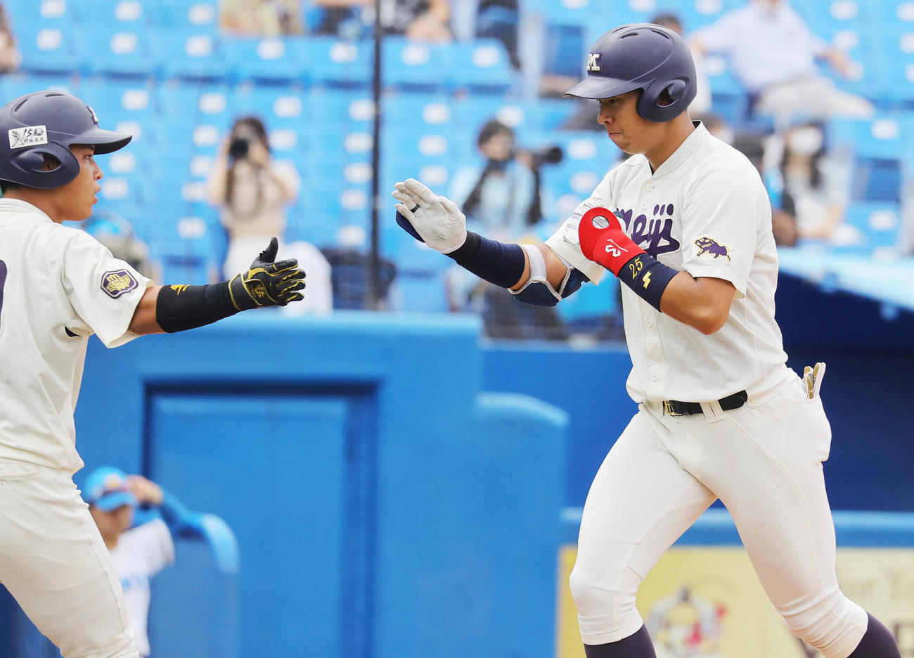 東大対明大　1回裏明大1死一塁、右越え2点本塁打を放ち蓑尾（左）に迎えられる上田（撮影・野上伸悟）