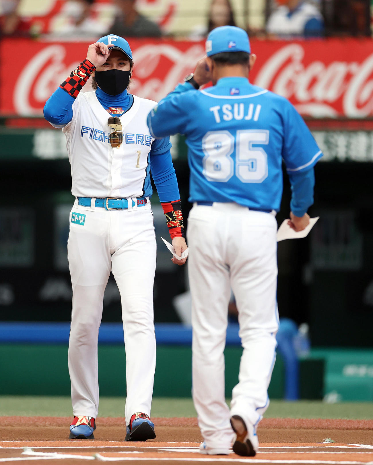 西武対日本ハム　試合前、メンバー表確認で辻監督（手前）とあいさつを交わす新庄監督（撮影・狩俣裕三）
