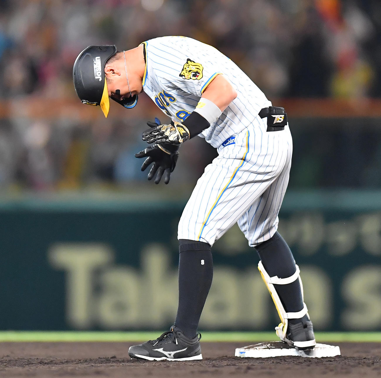 阪神対中日　6回裏阪神2死満塁、右翼線へ2点適時二塁打を放ち塁上で手をたたく佐藤輝（撮影・清水貴仁）