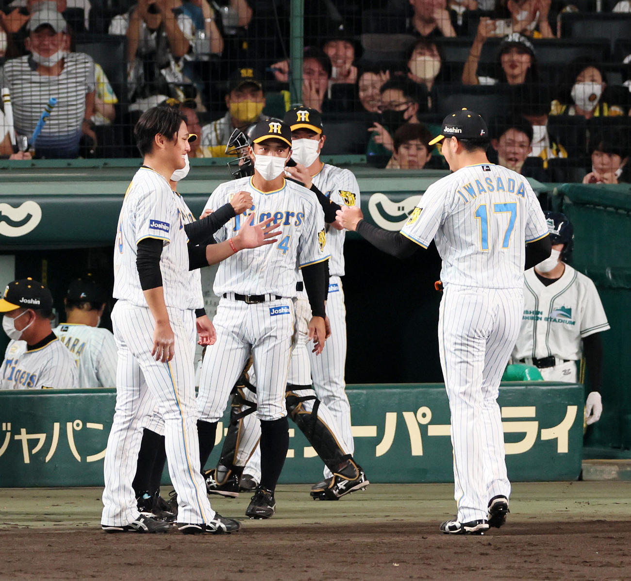 阪神対中日　6回表中日2死一、三塁、高橋を三振に仕留めベンチで西純（左）に迎えられる岩貞（撮影・加藤哉）