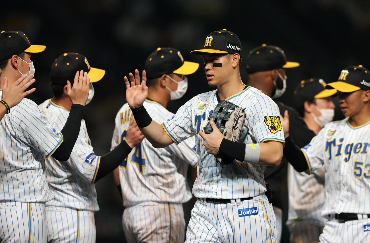 阪神対中日　中日に勝利しタッチを交わす阪神佐藤輝（手前）ら阪神の選手ら（撮影・上山淳一）