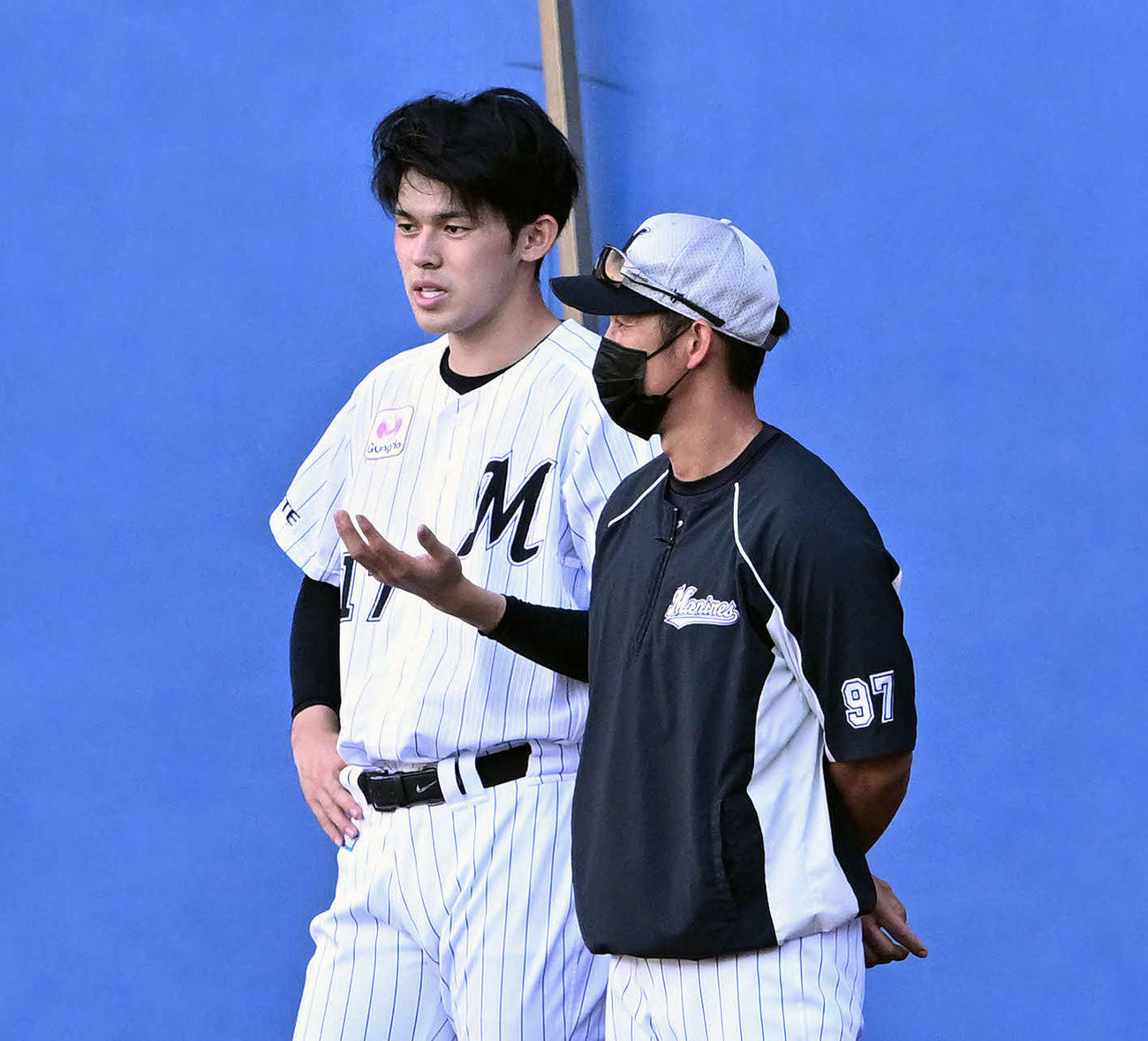 ロッテ対日本ハム　試合前練習でロッテ佐々木朗（左）は菊池トレーニングコーチと話す（撮影・滝沢徹郎）