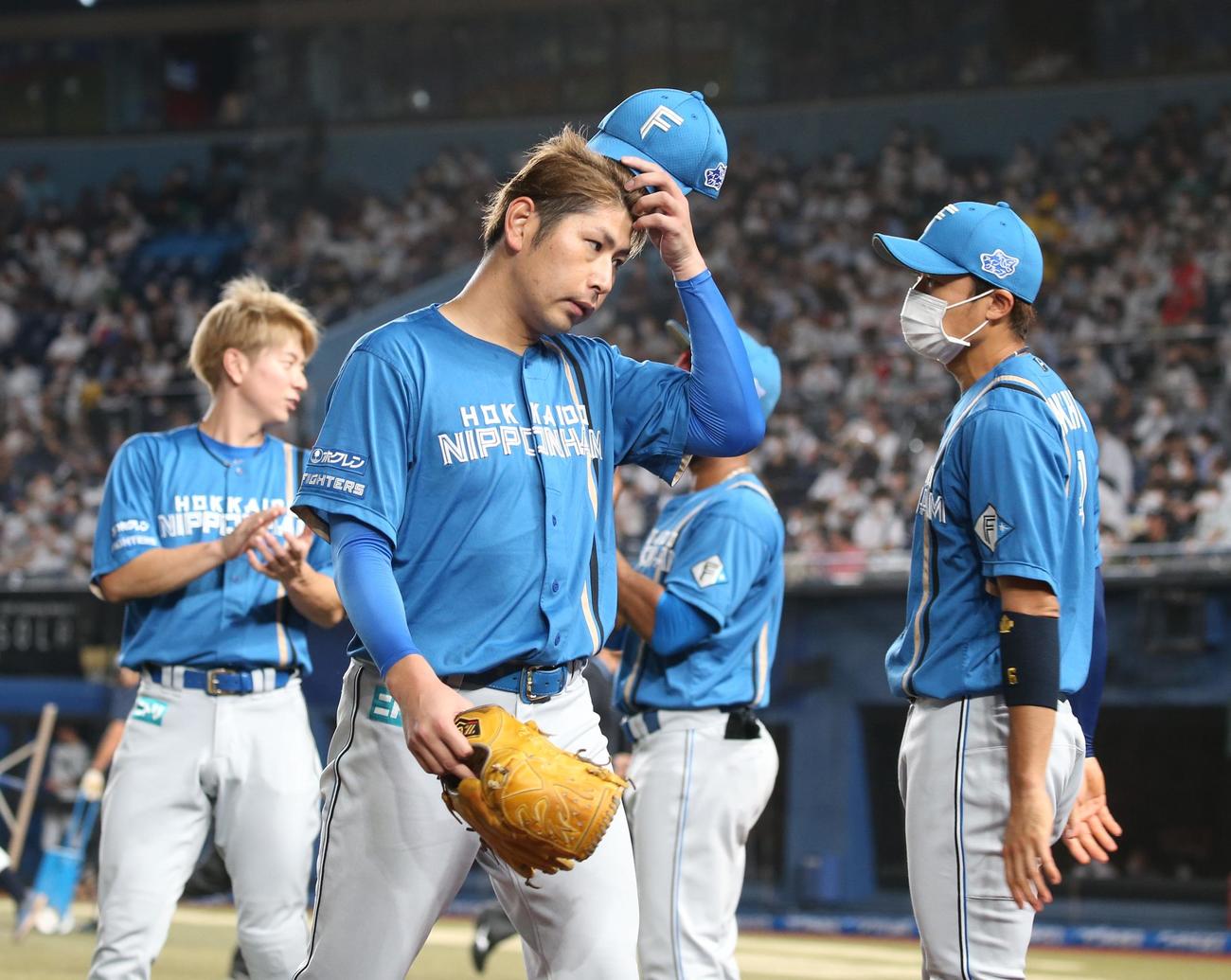 ロッテ対日本ハム　5回裏、頭をかきながら引き揚げる加藤（撮影・黒川智章）