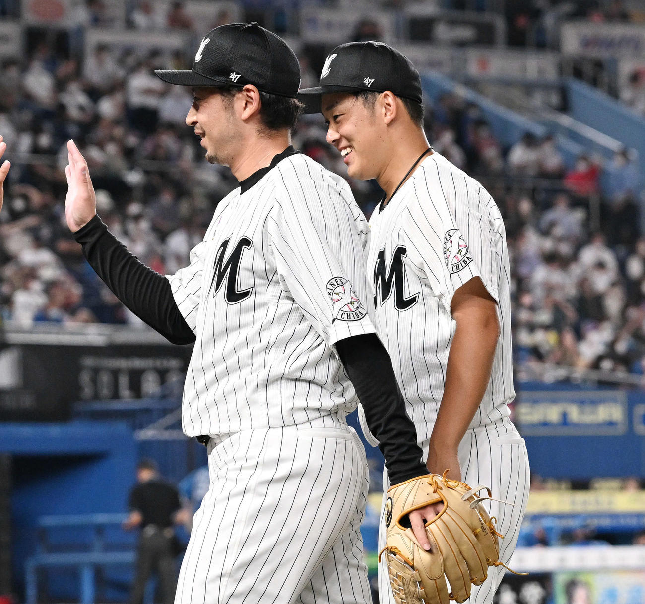 ロッテ対日本ハム　7回表、ロッテ2番手で投球した東條（左）を笑顔で迎える鈴木（撮影・滝沢徹郎）